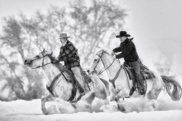 cowboys riding horses in snow black and white fine art photography
